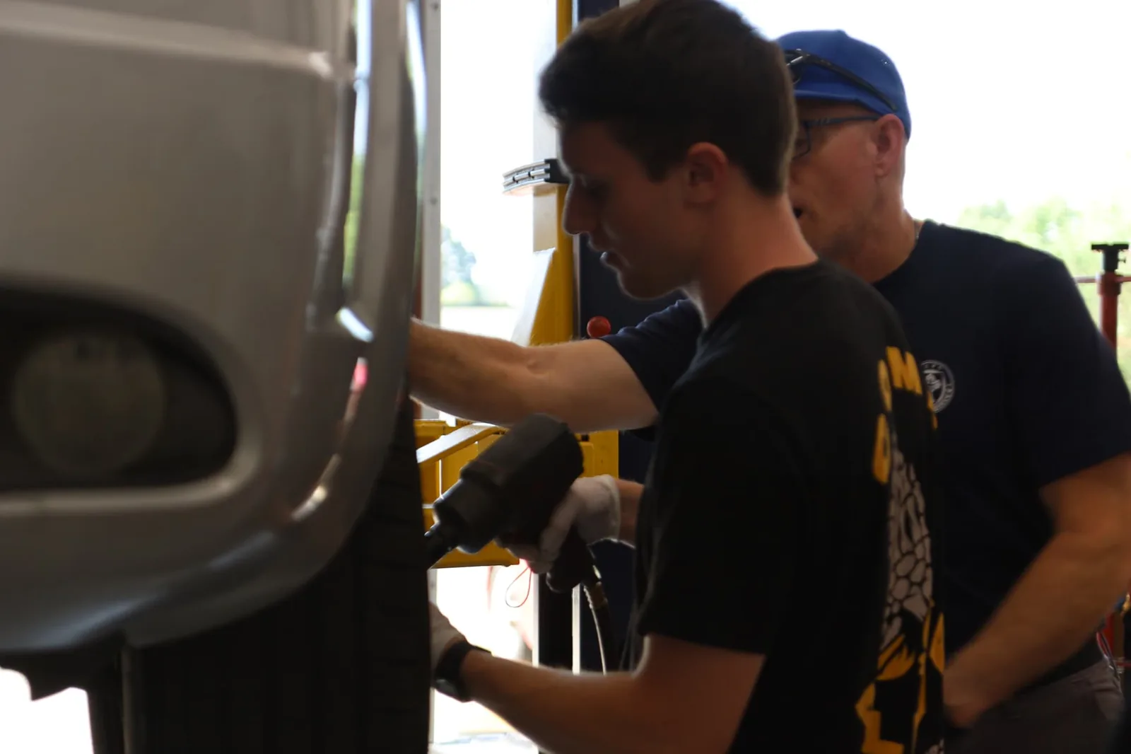 A volunteer mechanic working on a wheel assembly