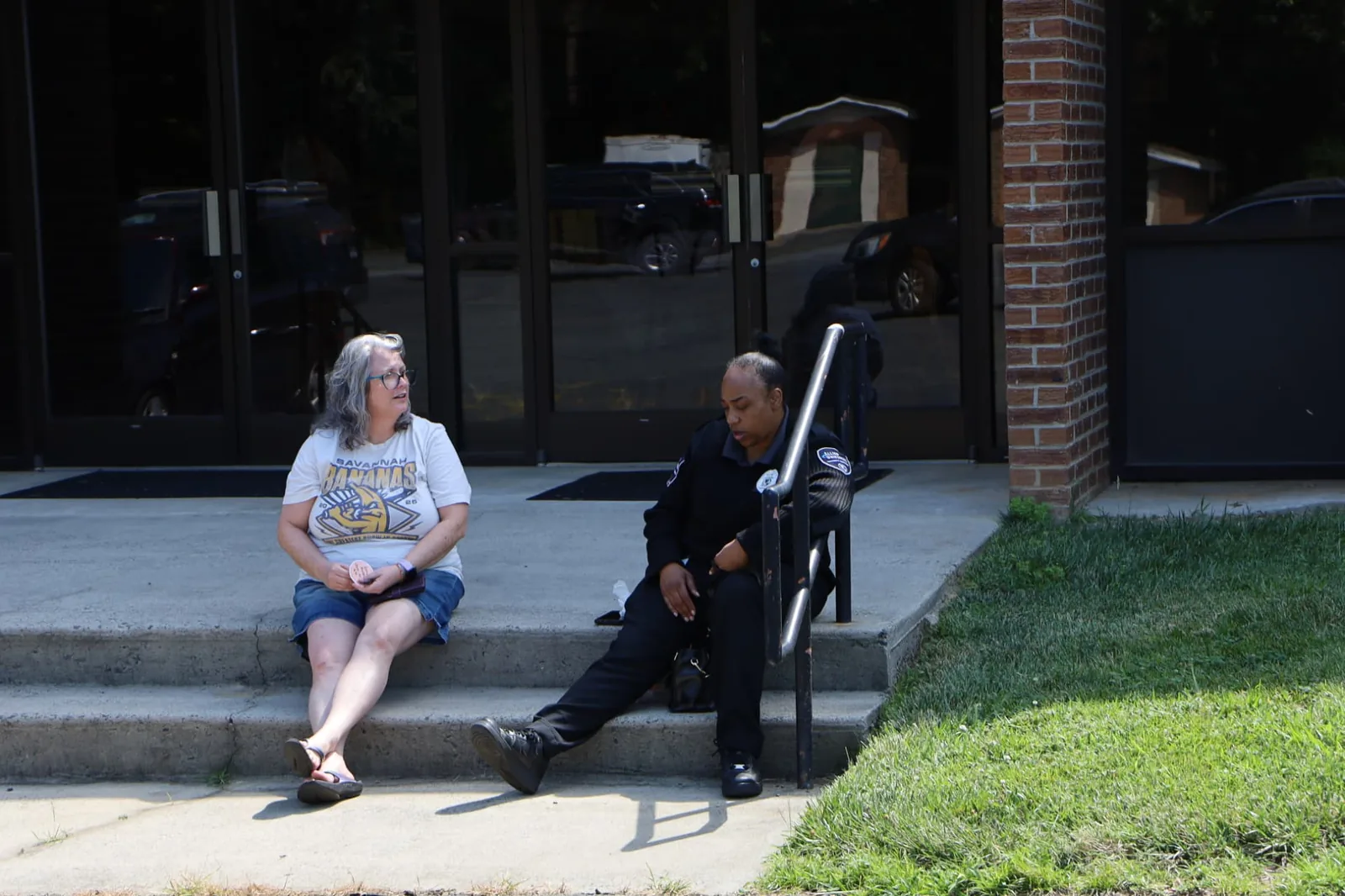 Two women talking outside during an auto repair Saturday